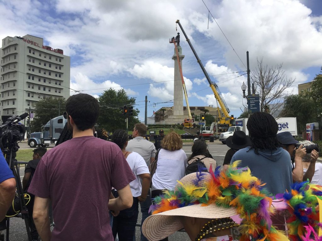 انبوهی از مردم در نیو اورلئان، می 2017، مشغول تماشای کارگران شهرداری هستند که با کمک جرثقیل برای برداشتن یکی از بناهای یادبود دولت موتلفه آمریکا تلاش می‌کنند.